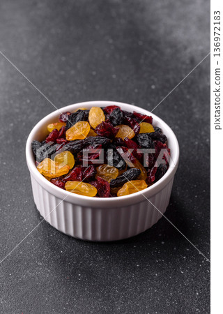 Dried cranberries, yellow and black sweet raisins as ingredients for a breakfast. Raisins and cranberries Dried cranberries, yellow and black sweet raisins as ingredients for a breakfast. Raisins and cranberries 136972183