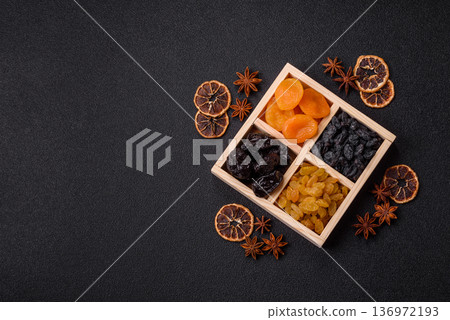 A variety of dried fruits, apricots, prunes, cranberries, raisins, figs, and dates for a healthy breakfast. A dried fruit mix 136972193