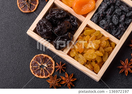 A variety of dried fruits, apricots, prunes, cranberries, raisins, figs, and dates for a healthy breakfast. A dried fruit mix 136972197
