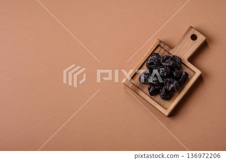 Sweet dried plums or prunes, organic dehydrated fruit for dietary nutrition. Prunes or dried plums 136972206