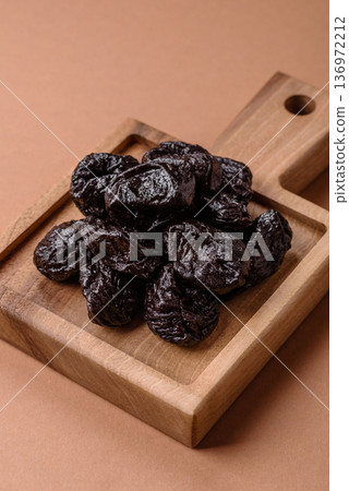 Sweet dried plums or prunes, organic dehydrated fruit for dietary nutrition. Prunes or dried plums 136972212