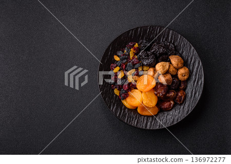 A variety of dried fruits, apricots, prunes, cranberries, raisins, figs, and dates for a healthy breakfast. A dried fruit mix A variety of dried fruits, apricots, prunes, cranberries, raisins, figs, and dates for a healthy breakfast. A dried fruit mix 136972277