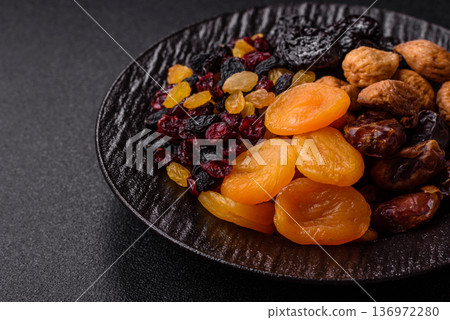A variety of dried fruits, apricots, prunes, cranberries, raisins, figs, and dates for a healthy breakfast. A dried fruit mix A variety of dried fruits, apricots, prunes, cranberries, raisins, figs, and dates for a healthy breakfast. A dried fruit mix 136972280