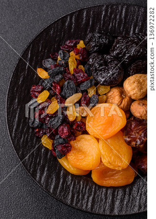 A variety of dried fruits, apricots, prunes, cranberries, raisins, figs, and dates for a healthy breakfast. A dried fruit mix A variety of dried fruits, apricots, prunes, cranberries, raisins, figs, and dates for a healthy breakfast. A dried fruit mix 136972282