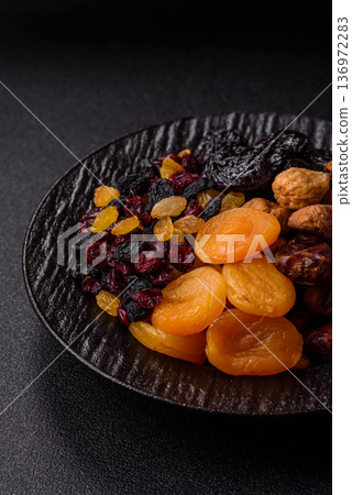 A variety of dried fruits, apricots, prunes, cranberries, raisins, figs, and dates for a healthy breakfast. A dried fruit mix A variety of dried fruits, apricots, prunes, cranberries, raisins, figs, and dates for a healthy breakfast. A dried fruit mix 136972283