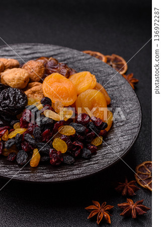 A variety of dried fruits, apricots, prunes, cranberries, raisins, figs, and dates for a healthy breakfast. A dried fruit mix A variety of dried fruits, apricots, prunes, cranberries, raisins, figs, and dates for a healthy breakfast. A dried fruit mix 136972287