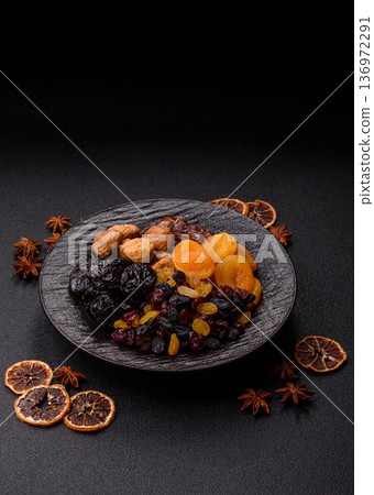 A variety of dried fruits, apricots, prunes, cranberries, raisins, figs, and dates for a healthy breakfast. A dried fruit mix 136972291
