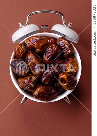 Vintage alarm clock on brown surface as a conceptual background for deadlines for tasks 136972323