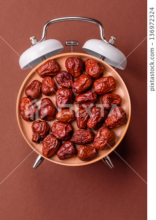 Vintage alarm clock on brown surface as a conceptual background for deadlines for tasks 136972324