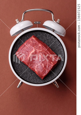 Vintage alarm clock on brown surface as a conceptual background for deadlines for tasks 136972325