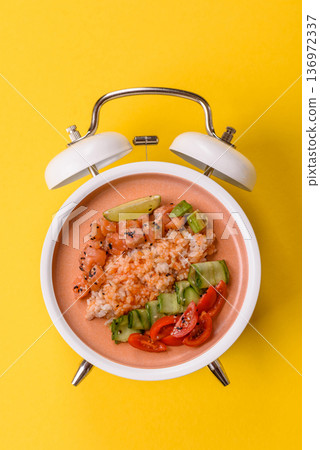 A food bowl with salmon, rice, avocado, tomatoes, and cucumbers. A salmon bowl A food bowl with salmon, rice, avocado, tomatoes, and cucumbers. A salmon bowl 136972337