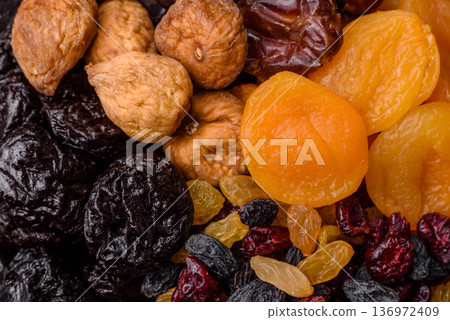 A variety of dried fruits, apricots, prunes, cranberries, raisins, figs, and dates for a healthy breakfast. A dried fruit mix A variety of dried fruits, apricots, prunes, cranberries, raisins, figs, and dates for a healthy breakfast. A dried fruit mix 136972409