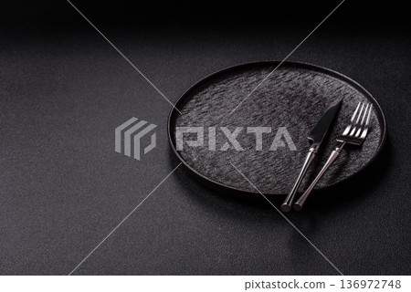 An empty round ceramic plate, knife, and fork as a dining table setting. An empty plate An empty round ceramic plate, knife, and fork as a dining table setting. An empty plate 136972748