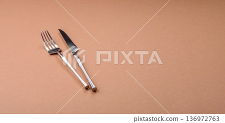 A knife and fork, silver kitchen utensils for the dining table. A knife and fork A knife and fork, silver kitchen utensils for the dining table. A knife and fork 136972763