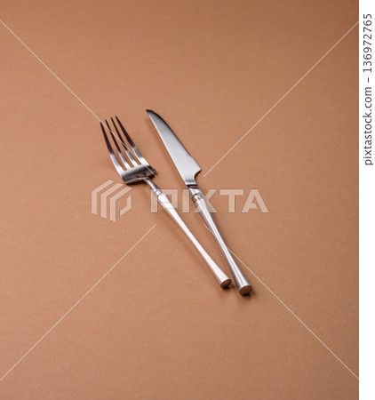 A knife and fork, silver kitchen utensils for the dining table. A knife and fork A knife and fork, silver kitchen utensils for the dining table. A knife and fork 136972765