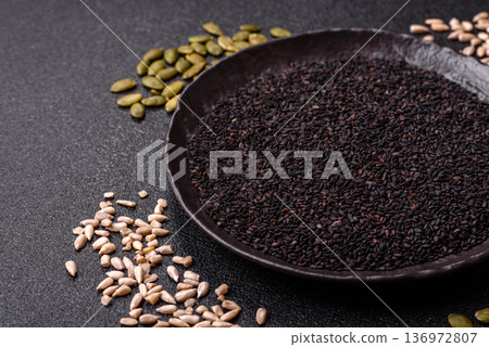Black sesame seeds in a bowl, an ingredient for oil and healthy eating. Black sesame Black sesame seeds in a bowl, an ingredient for oil and healthy eating. Black sesame 136972807
