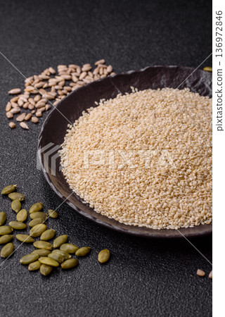 White sesame seeds in a bowl, an ingredient for oil and healthy eating. White sesame White sesame seeds in a bowl, an ingredient for oil and healthy eating. White sesame 136972846