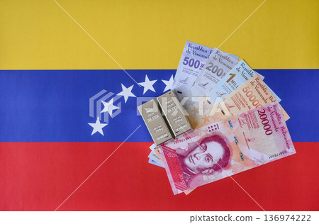 A silver bar, white metal against a flag of venezuela, as a concept for the sales. A silver bar A silver bar, white metal against a flag of venezuela, as a concept for the sales. A silver bar 136974222