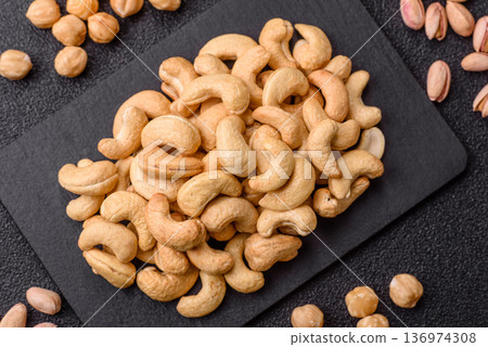 Roasted or raw cashew make a savory snack for a healthy, filling meal. Cashew nuts Roasted or raw cashew make a savory snack for a healthy, filling meal. Cashew nuts 136974308