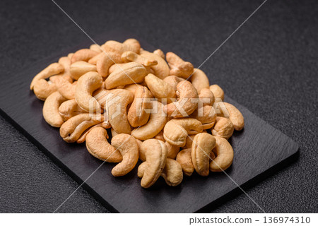 Roasted or raw cashew make a savory snack for a healthy, filling meal. Cashew nuts Roasted or raw cashew make a savory snack for a healthy, filling meal. Cashew nuts 136974310