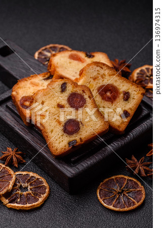 Fruit cake, a dessert with cherries, plums, and raisins for a festive Christmas table. Fruit cake Fruit cake, a dessert with cherries, plums, and raisins for a festive Christmas table. Fruit cake 136974315