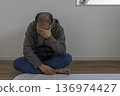 一名男子坐在房間裡，神情沮喪（日本人，30多歲，無臉） 136974427