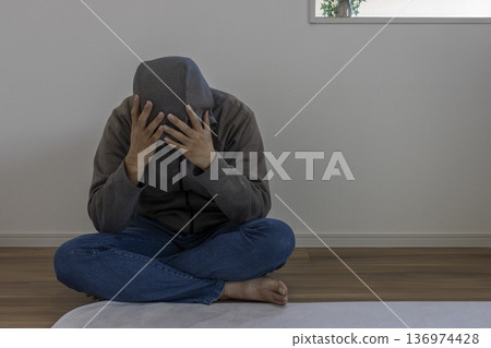 一名男子坐在房間裡，神情沮喪（日本人，30多歲，無臉） 136974428