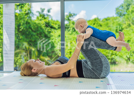 Mother doing fitness exercises while holding her baby at home, combining workout and childcare. Real lifestyle moment showing balance, strength and love. Postpartum fitness, healthy motherhood and Mother doing fitness exercises while holding her baby at home, combining workout and childcare. Real lifestyle moment showing balance, strength and love. Postpartum fitness, healthy motherhood and 136974634
