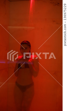Expressive dancer recovering after practice under warm red steam light Expressive dancer recovering after practice under warm red steam light 136975229