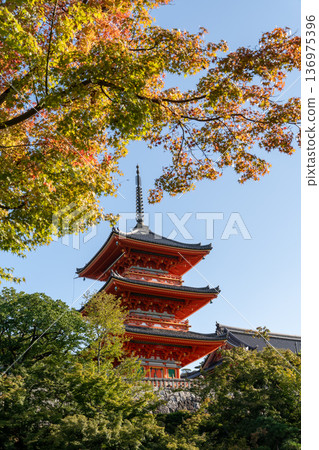 Red Japanese pagoda temple framed by autumn leaves in Kyoto, Japan Red Japanese pagoda temple framed by autumn leaves in Kyoto, Japan 136975396