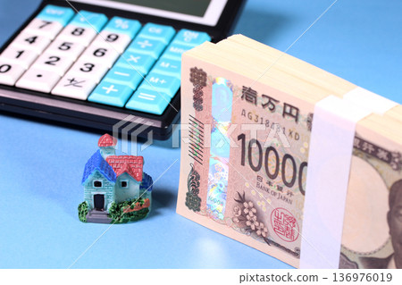 一疊嶄新的鈔票、一座微縮房屋和一個計算器（房地產和抵押貸款的圖片） 136976019