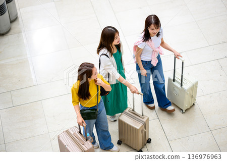 Three women traveling and talking at the airport. Photo courtesy of Kansai International Airport (KIX). Three women traveling and talking at the airport. Photo courtesy of Kansai International Airport (KIX). 136976963
