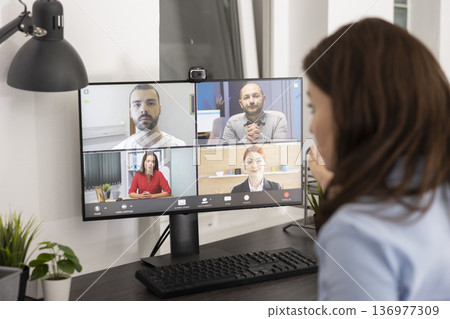 Businesswoman conducts project briefing from desk, speaks to colleagues through online video conference. Female manager explains to shareholders about strategy, shares new information on company tasks Businesswoman conducts project briefing from desk, speaks to colleagues through online video conference. Female manager explains to shareholders about strategy, shares new information on company tasks 136977309
