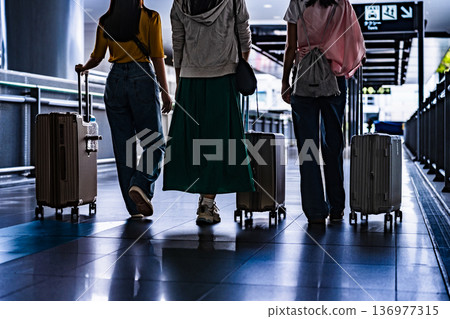 Three people pulling suitcases at the airport ■Photography cooperation: Kansai International Airport (KIX) Three people pulling suitcases at the airport ■Photography cooperation: Kansai International Airport (KIX) 136977315