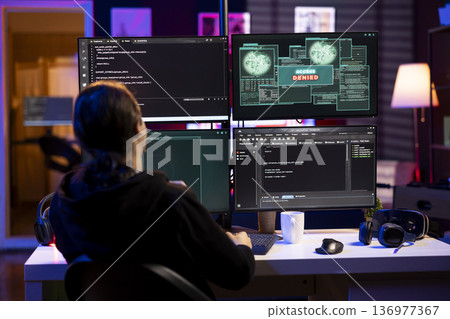 Hacker at home getting access denied error while doing computer sabotage using ransomware. Rogue programmer failing to penetrate firewalls while trying to steal victim data 136977367