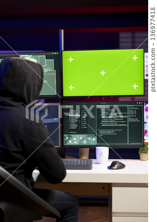 Hacker using green screen PC to gain unauthorized network access, targeting unpatched connections. Man using mockup computer to bypass security and exploit servers for stolen data profit 136977418