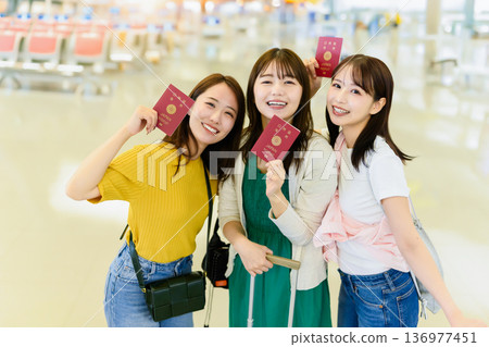 Three girls leaving with their passports in hand. Photo courtesy of Kansai International Airport (KIX) 136977451