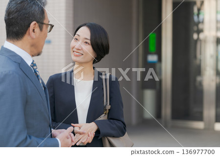 穿著西裝的男人和女人聊天 穿著西裝的男人和女人聊天 136977700