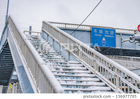 Snow-covered pedestrian bridge Sign for Hongo-Ikebukuro area Winter cityscape 136977705
