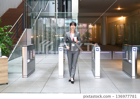 一位身穿西裝的女商人正在通過安檢門。 136977781