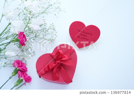 A gift and red carnations to express gratitude on an anniversary A gift and red carnations to express gratitude on an anniversary 136977814