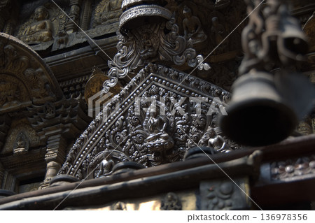 尼泊爾寺廟裡精美的銀質佛像雕刻和懸掛的鈴鐺 136978356