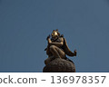 尼泊爾，一座金色的神像和鴿子雕像矗立在藍天下。 136978357