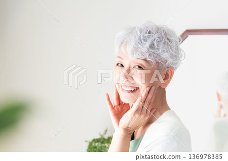 Senior woman feeling the moisture in her skin 136978385