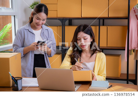Two asian woman working in small business online store, online seller. Two asian woman working in small business online store, online seller. 136978554