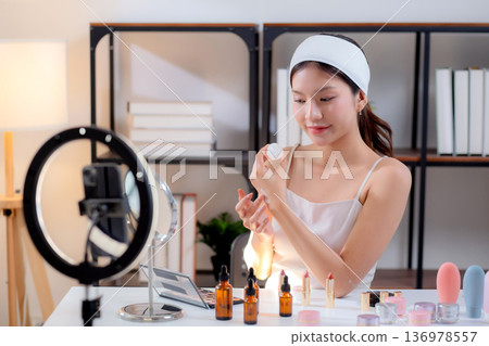 Young asian woman presenting and review cosmetic product with on social media. 136978557