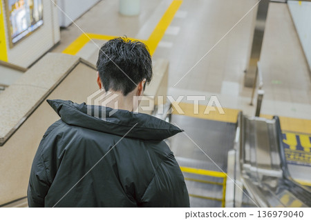一名身穿羽絨外套的男子，脖子和整潔的後頸，手扶梯 136979040
