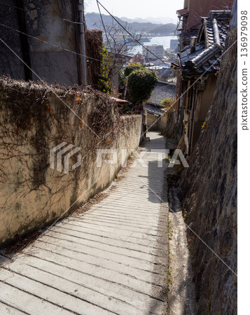 Onomichi's hidden beauty: A glimpse of the ocean beyond the buildings and a landscape with depth created by the slopes Onomichi's hidden beauty: A glimpse of the ocean beyond the buildings and a landscape with depth created by the slopes 136979098