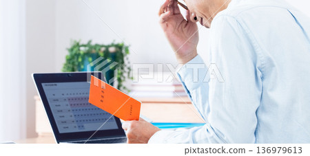 A middle-aged man thinking while looking at his pension book A middle-aged man thinking while looking at his pension book 136979613