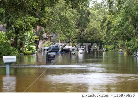 Hurricane Debby flooded city street with trapped cars submerged under water in Florida residential area. Consequences of natural disaster 136979650